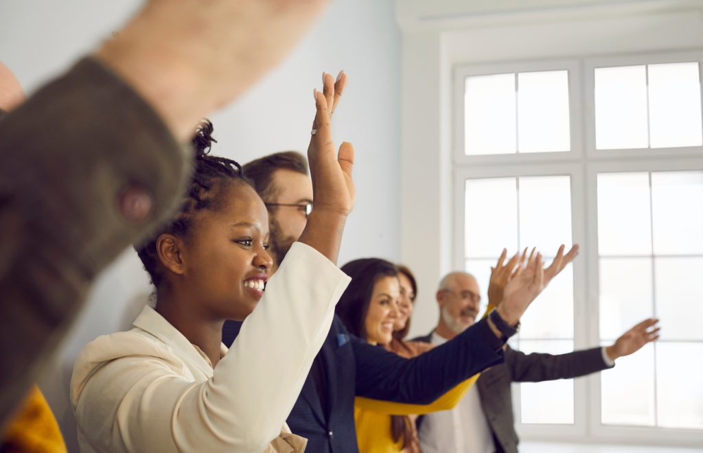 Diverse,Male,And,Female,Audience,Standing,In,Row,And,Raising