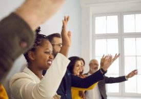Diverse,Male,And,Female,Audience,Standing,In,Row,And,Raising